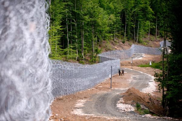 Bulgarian border police personal stand next to a barbed wire fence at the border between Bulgaria and Turkey near the Bulgarian town of Malko Tarnovo