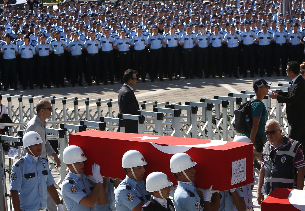 Turkish honor guards carry the coffin of a policeman killed Friday during the failed military coup during a mass funeral in Ankara Turkey Sunday