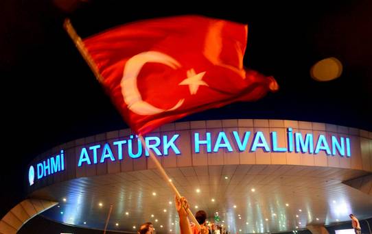 A man waves a Turkish flag in front of Ataturk Airport during an attempted coup in Istanbul. Turkish Airlines have since resumed flights from the airport. REUTERS  IHLAS News Agency