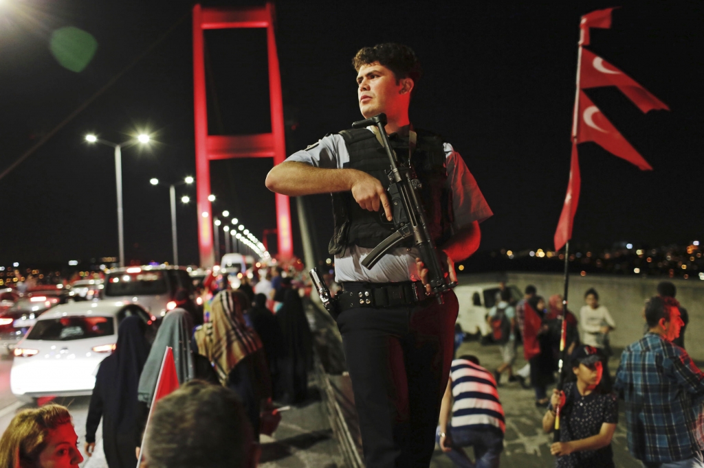 A Turkish police officer patrols as pro-government supporters gather on Istanbul's iconic Bosporus Bridge Thursday