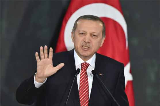 Turkish President Recep Tayyip Erdogan walks between the honor guards wearing historic Turkish warriors