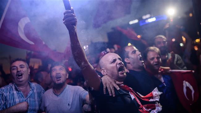 Turks chant slogans and gesture as they gather for a rally following the failed coup at Taksim Square in Istanbul