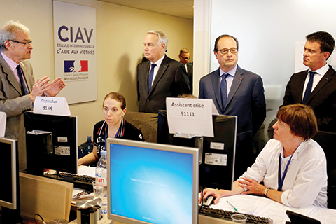 TOPSHOT- French Prime minister Manuel Valls, French President Francois Hollande and French Foreign minister Jean Marc Ayrault visit the Interministerial Victim Support Unit at the Foreign Ministry in Paris