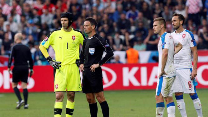 Referee Mark Clattenburg talks with Czech goalkeeper Petr Cech after falres were thrown