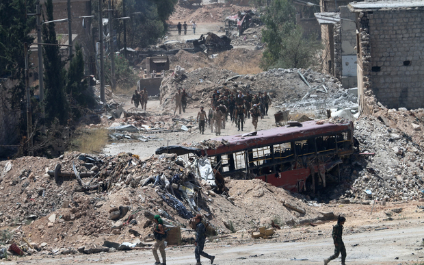 Syrian army soldiers patrol the area around the entrance of Bani Zeid after taking control of the previously rebel-held district of Leramun on the northwest outskirts of Aleppo