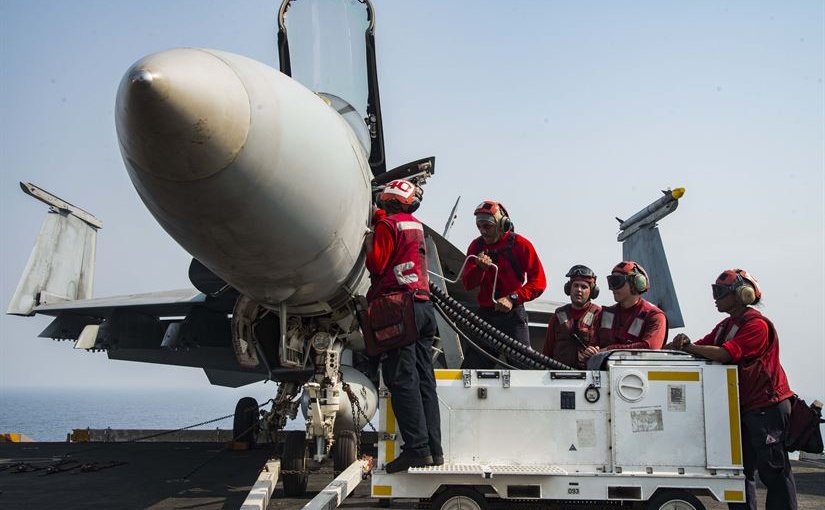 Aviation crew load ordnance into an F  A-18E Super Hornet assigned to the Gunslingers of Strike Fighter Squadron 105 on the flight deck of the aircraft carrier USS Dwight D. Eisenhower in the Arabian Gulf in preparation for a mission in support of Operatio