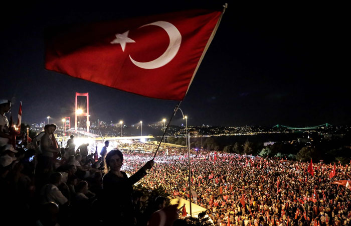 Pro Erdogan supporters wave a Turkish national flag during a rally at Bosphorus bridge in Istanbul. Thousands of Turkish government supporters streamed across one of the two bridges spanning the Bosphorus in Istanbul to protest against the coup that sough