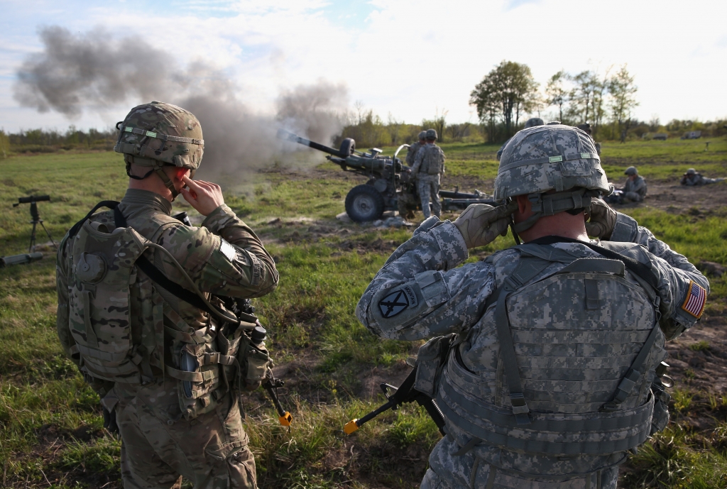 FORT DRUM NY- MAY 18 The 10th Mountain Division soldiers plug their ears while comrades fire a 105mm Howitzer during a training mission for future conflicts