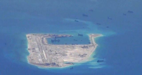 Chinese dredging vessels are purportedly seen around Fiery Cross Reef in the disputed Spratly Islands in the South China Sea in this image from video taken by a P-8A Poseidon surveillance aircraft provided by the U.S. Navy