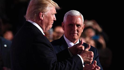 Republican vice presidential nominee Mike Pence claps as presidential candidate Donald Trump gestures during the Republican National Convention at the Quicken Loans Arena in Cleveland Ohio