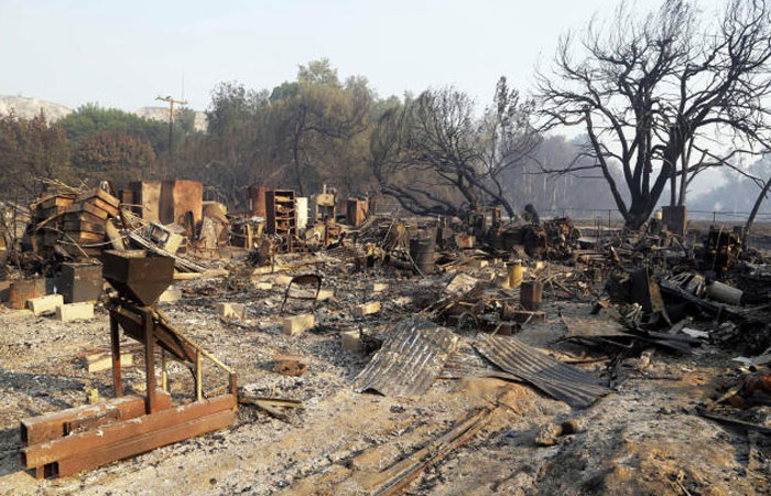 Burned-out vehicles and film sets at Sable Ranch which has Old West-style buildings used for movie locations in Santa Clarita California are seen Monday morning after the massive Sand wildfire swept through the area over the weekend. — AP