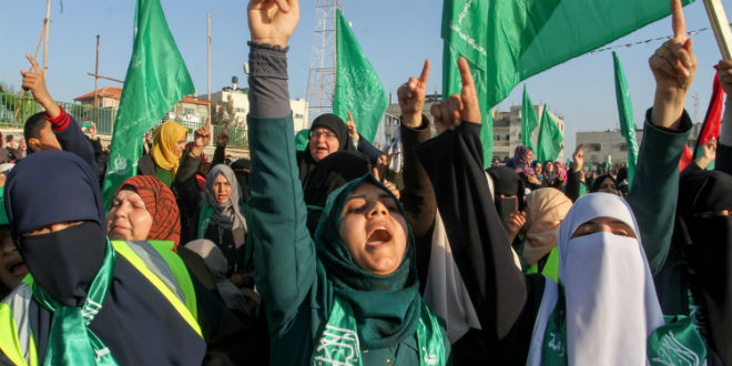 Palestinians watch an anti Israel rally organised by the Hamas movement in Rafah in the southern Gaza Strip