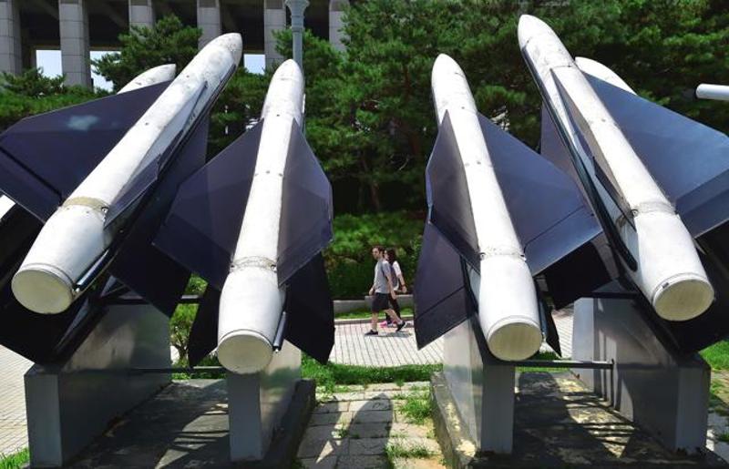 Visitors walk past replicas of South Korean Hawk surface-to-air missiles at the Korean War Memorial in Seoul on Friday