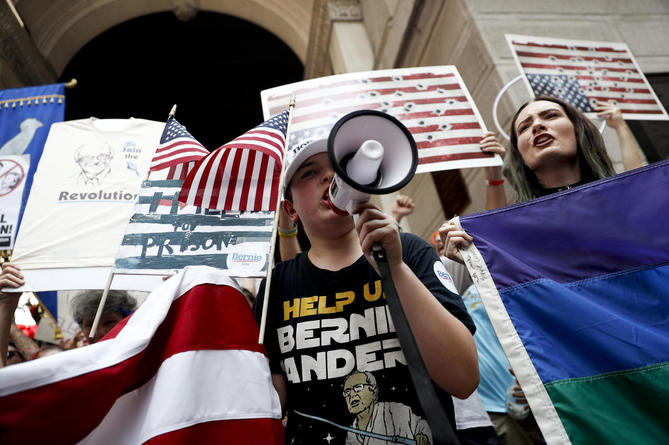 Pro-Sanders demonstrators march in the sweltering heat