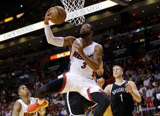 Miami Heat guard Dwyane Wade shoots in front of Brooklyn Nets center Mason Plumlee during the first half of an NBA basketball game in Miami. Wade has been extended a two-year $40 million contract offer