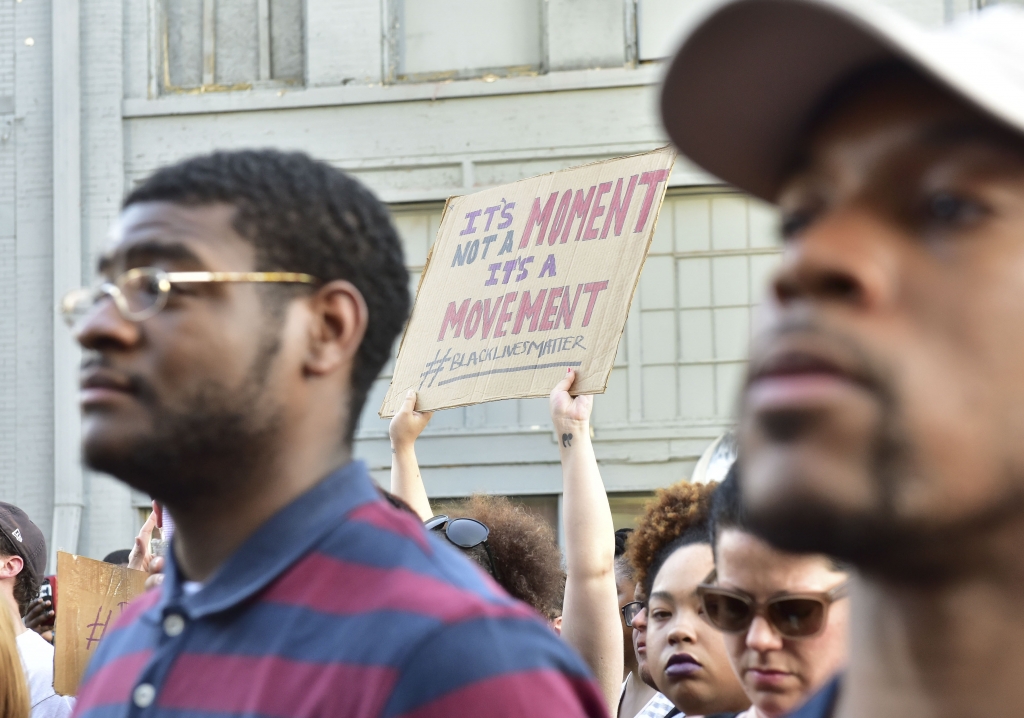 Protesters hold signs up at a brief rally in front of the Birmingham Police Headquarters. A solidarity protest and march held at Kelly Ingram Park saw hundreds of people listen to speakers chant and march to Birmingham Police Headquarters. (Frank Couch