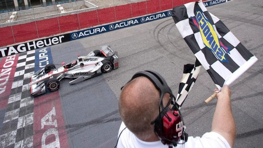 Will Power of Australia takes the checkered flag as he crosses the finish line to win the Indy Car auto race in Toronto on Sunday