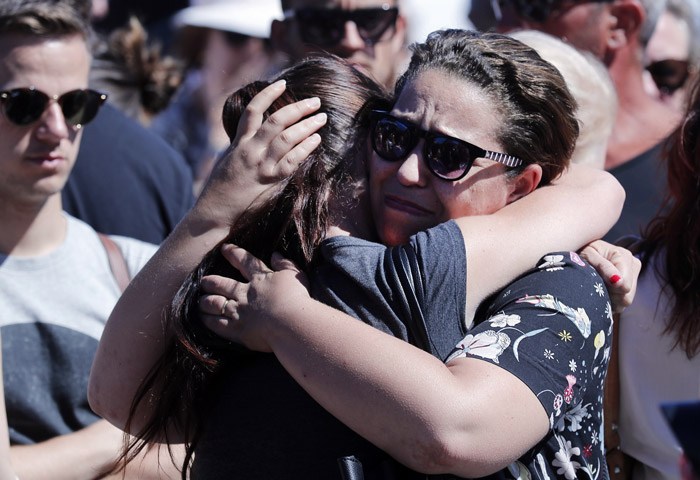 Women react near the scene where a truck mowed through revelers in Nice southern France Friday