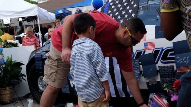 Melvin Lopez brought his five-year old son Kevin to Dallas police headquarters to honour the officers shot and killed by Micah Johnson