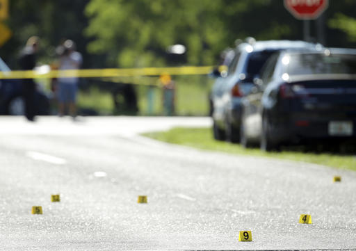 Evidence markers are placed on the street at the scene of a deadly shooting outside of the Club Blu nightclub Monday