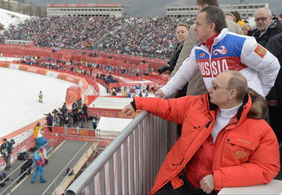 8 2014 Russian President Vladimir Putin foreground watches downhill ski competition of the 2014 Winter Paralympics in Roza Khutor mountain district of Sochi Russia as Russia's sports minister Vitaly Mu