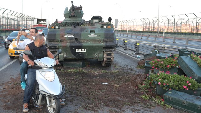 People by Turkish army tanks on a road in Istanbul