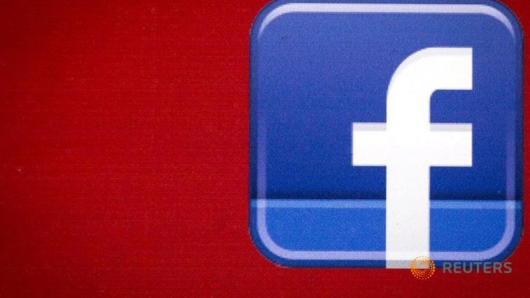 A Facebook logo is displayed on the side of a tour bus in New York's financial district