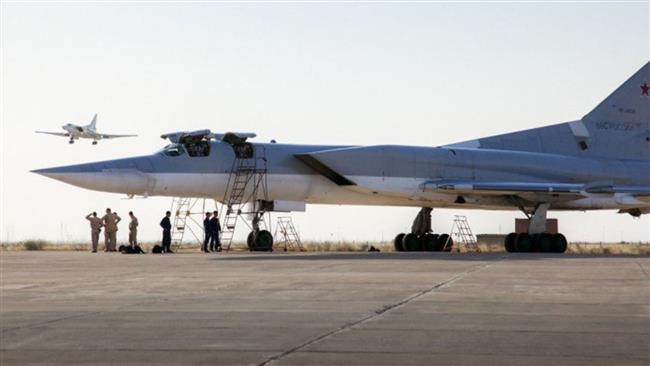 A Russian Tu-22 M3 bomber stands on the tarmac while another plane lands at the Nojeh Airbase near Hamedan on August 15