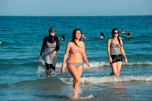 A Tunisian women wearing a burkini walking in the water at Ghar El Melh beach near Bizerte north-east of the capital Tunis