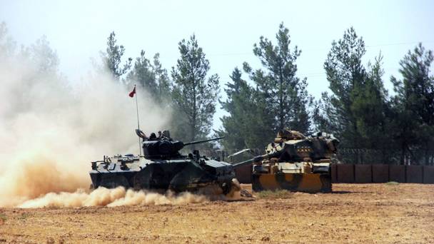 A Turkish army tank and an armoured vehicle are stationed near the border with Syria in Karkamis Turkey