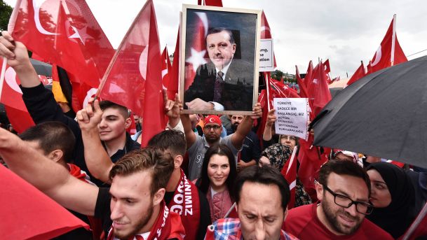 A Turkish protester holds a portrait of Turkish President Erdogan during a demonstration in Cologne Germany