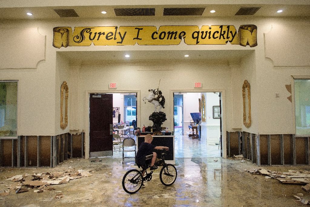 A boy rides his bike inside the flood-damaged Life Tabernacle Church on Aug 15 2016 in Baton Rouge Louisiana