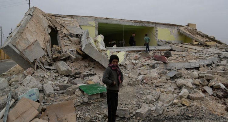 A child standing in front of his ground-flattened school after a bombardment in Ainjara village in rural Aleppo Syria