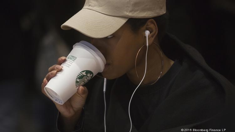 A customer drinks a beverage inside a Starbucks Corp. coffee shop in New York