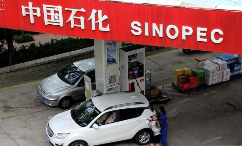 A customer gets the tank of her car filled at a Sinopec gas station in Qingdao Shandong province China