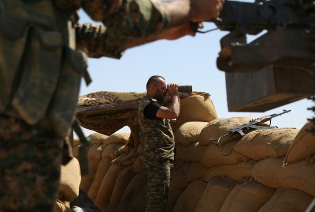 A fighter from the Kurdish People Protection Unit monitors the front line in the northeastern Syrian city of Hasakeh