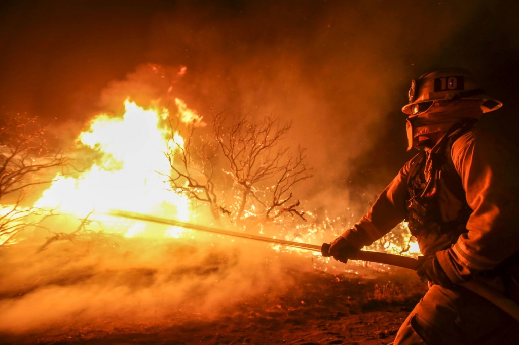 A firefighter battles the Blue Cut wildfire burning near Cajon Pass north of San Bernardino