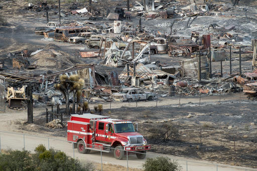 A firetruck passes scorched cars and trailers burned by the Blue Cut fire in Phelan Calif. on Friday Aug. 19 2016