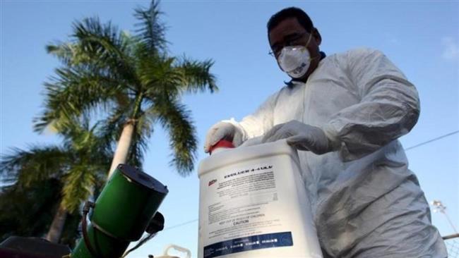 A health worker prepares insecticide before fumigating a neighborhood in San Juan Puerto Rico in this