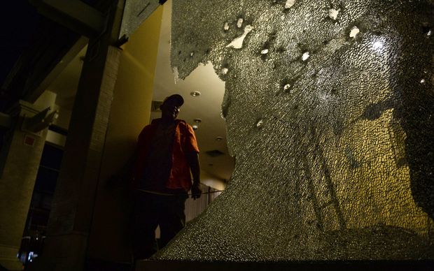 A labourer inspects the damage done to the glass windows of a Starbucks branch next to the site of a bomb attack in Hua Hin