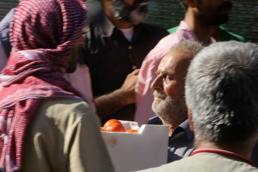 A man carries a box of tomatoes he received as food aid in Aleppo Syria