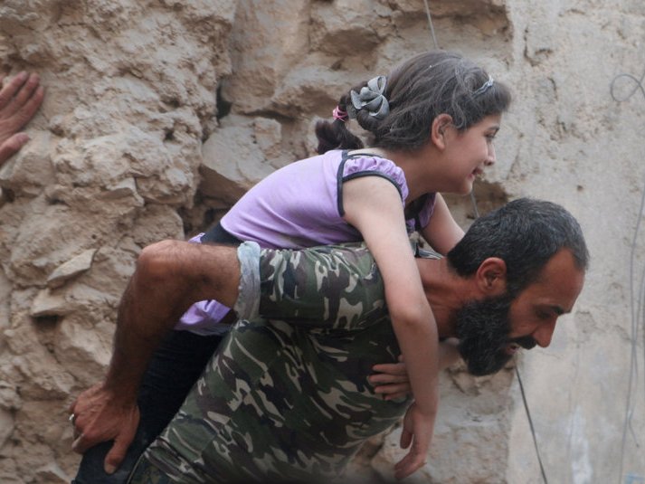 A man carries an injured girl after an airstrike on Aleppo's rebel held Kadi Askar area Syria