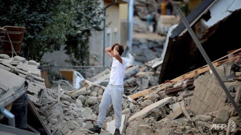 A man stands among damaged buildings after a strong earthquake hit central Italy in Amatrice