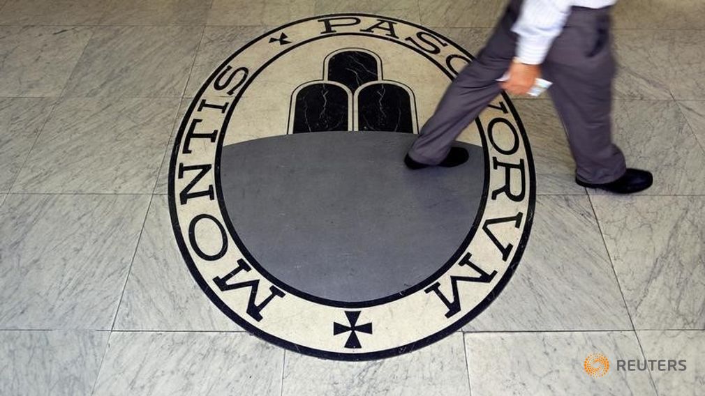 A man walks on a logo of the Monte Dei Paschi Di Siena bank in Rome Italy