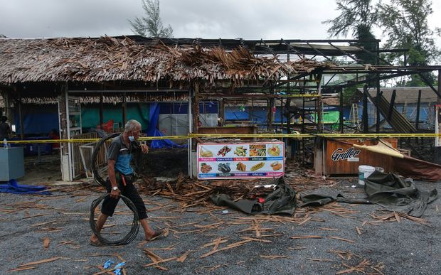 A man walks past the site of a small bomb blast and arson attack on Bang Niang market Takua Pa near Khao Lak in Phang Nga province Thailand