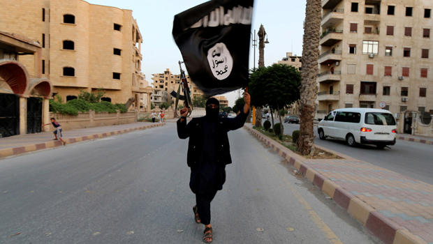 A member loyal to the Islamic State of Iraq and Syria waves a flag in Raqqa Syria