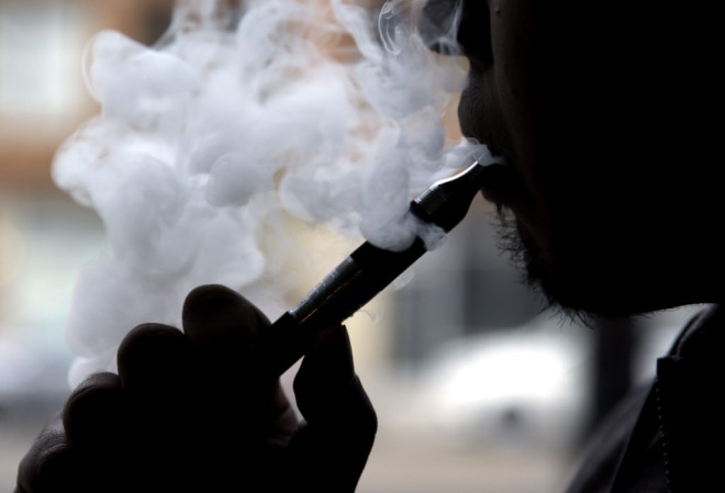 A person vapes outside a restaurant. THE ASSOCIATED PRESS