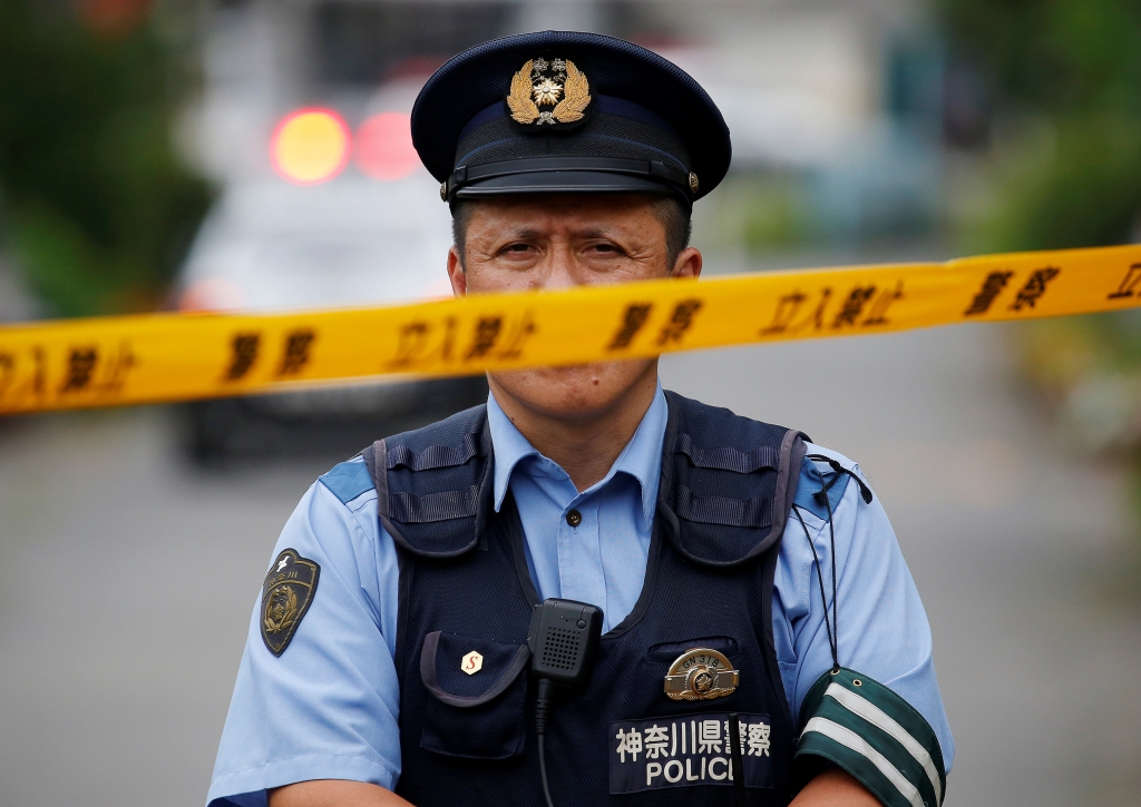 A policeman guards the carehome where Satoshi Uematsu is accused of slitting the throats of disabled residentsReuters