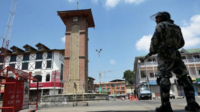 A security jawan stands guard at Lal chowk during curfew in Srinagar