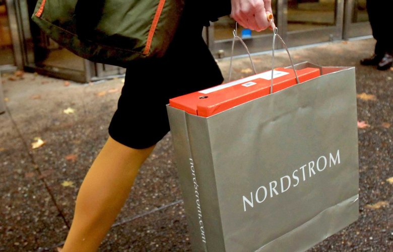 A shopper walks in downtown Seattle after purchasing a pair of boots from Nordstrom